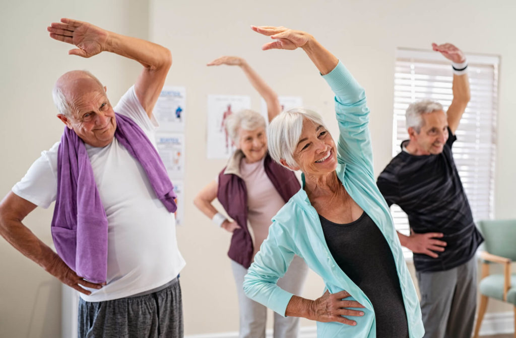 A group of seniors exercising in a senior living facility.