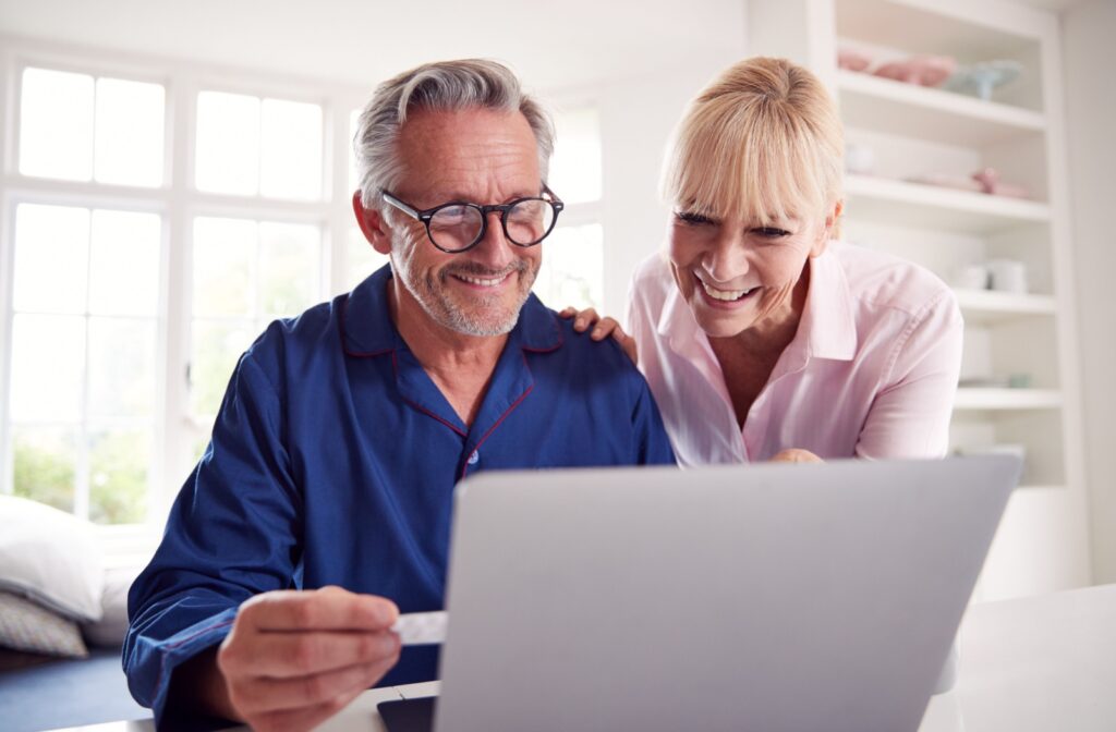 An older couple sitting at their kitchen table and researching independent living communities together.
