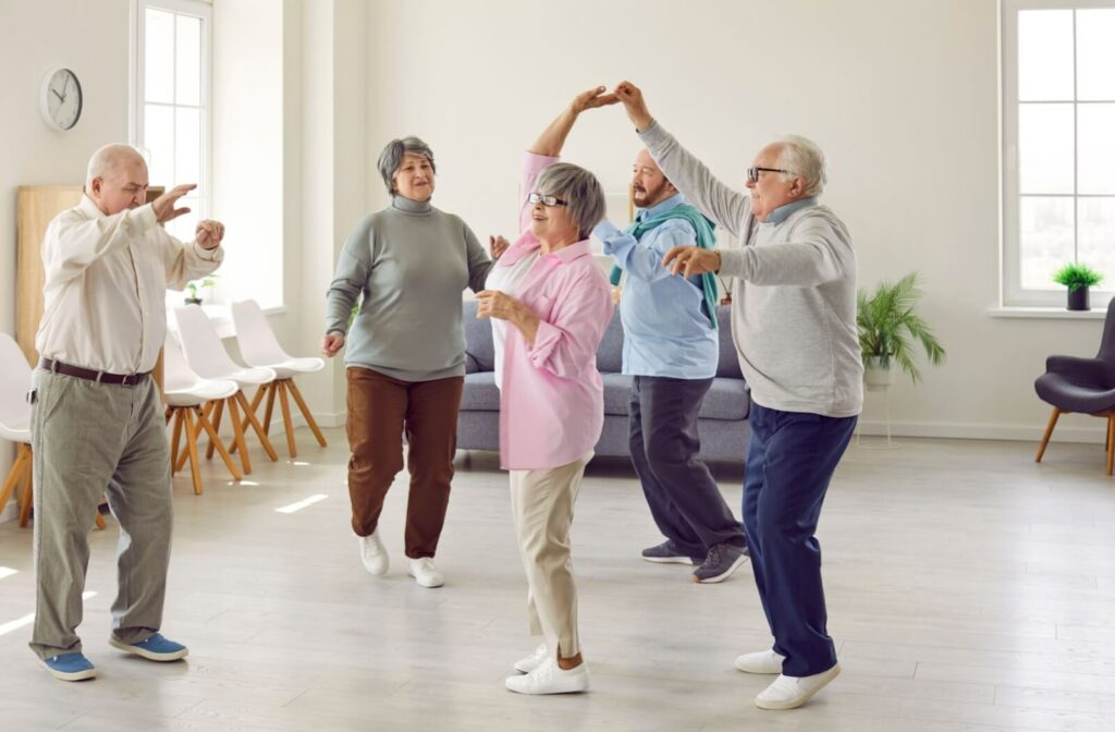 A group of seniors dances together in their community's common area.